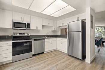 A kitchen with white cabinets and stainless steel appliances. at Parkway Plaza Apartments, California, 90230